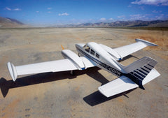 back angled view of 126" Cessna 310 facing a mountain range